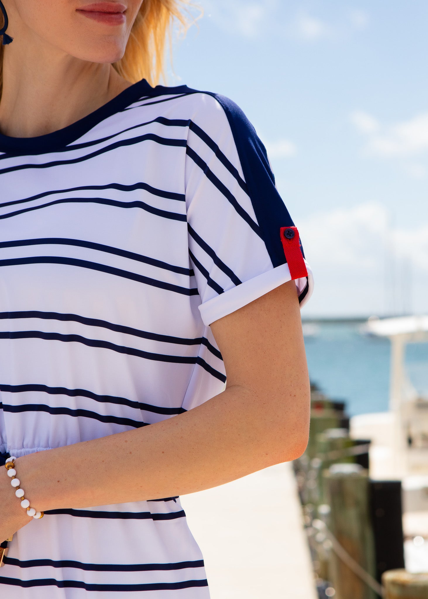Person wearing a white and navy striped shirt with a blurred background