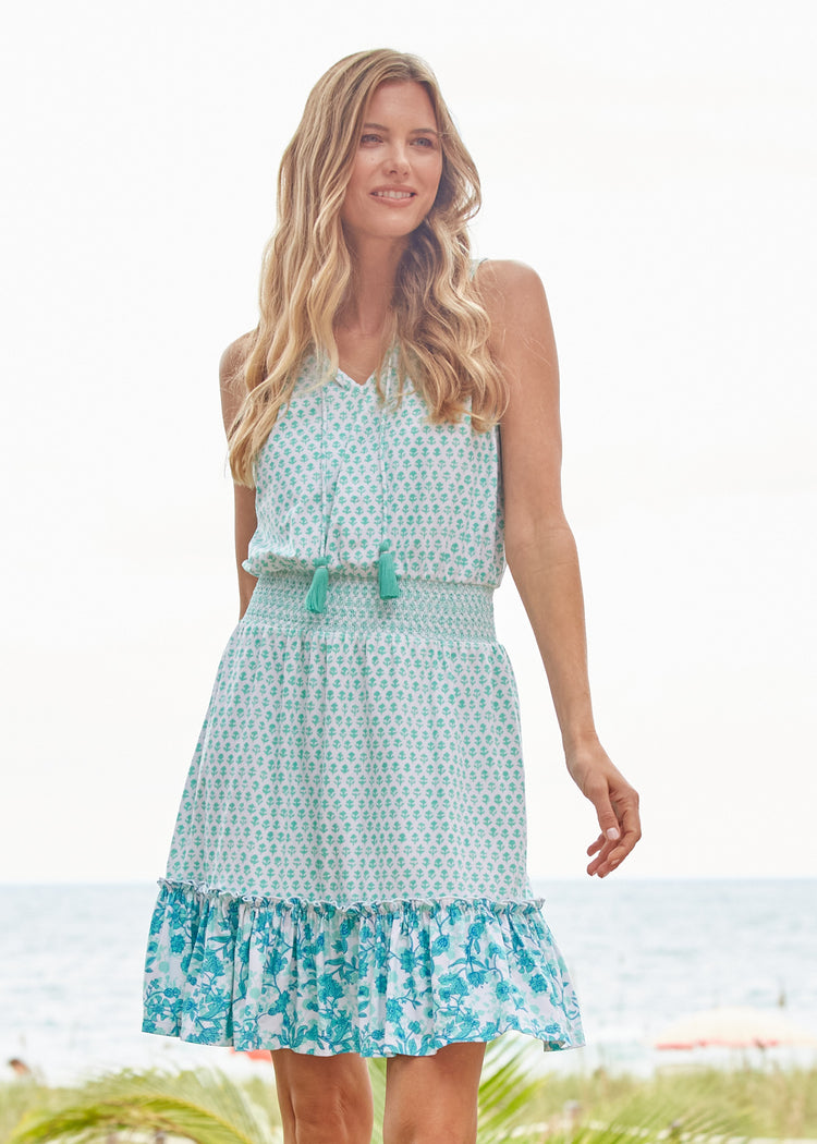 Woman wearing a light blue dress with floral pattern on a beach