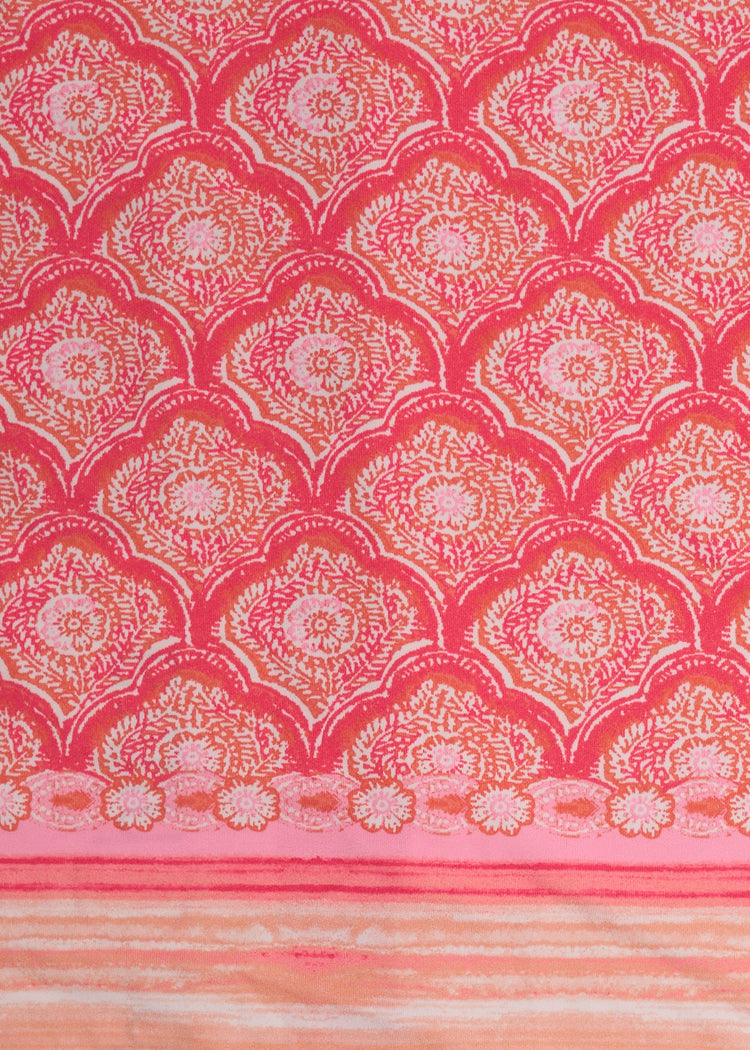 A close up of Cabana Life's Amelia Island pink and coral colored tile print with a watercolor stripe border on a UPF 50+ woven fabric.