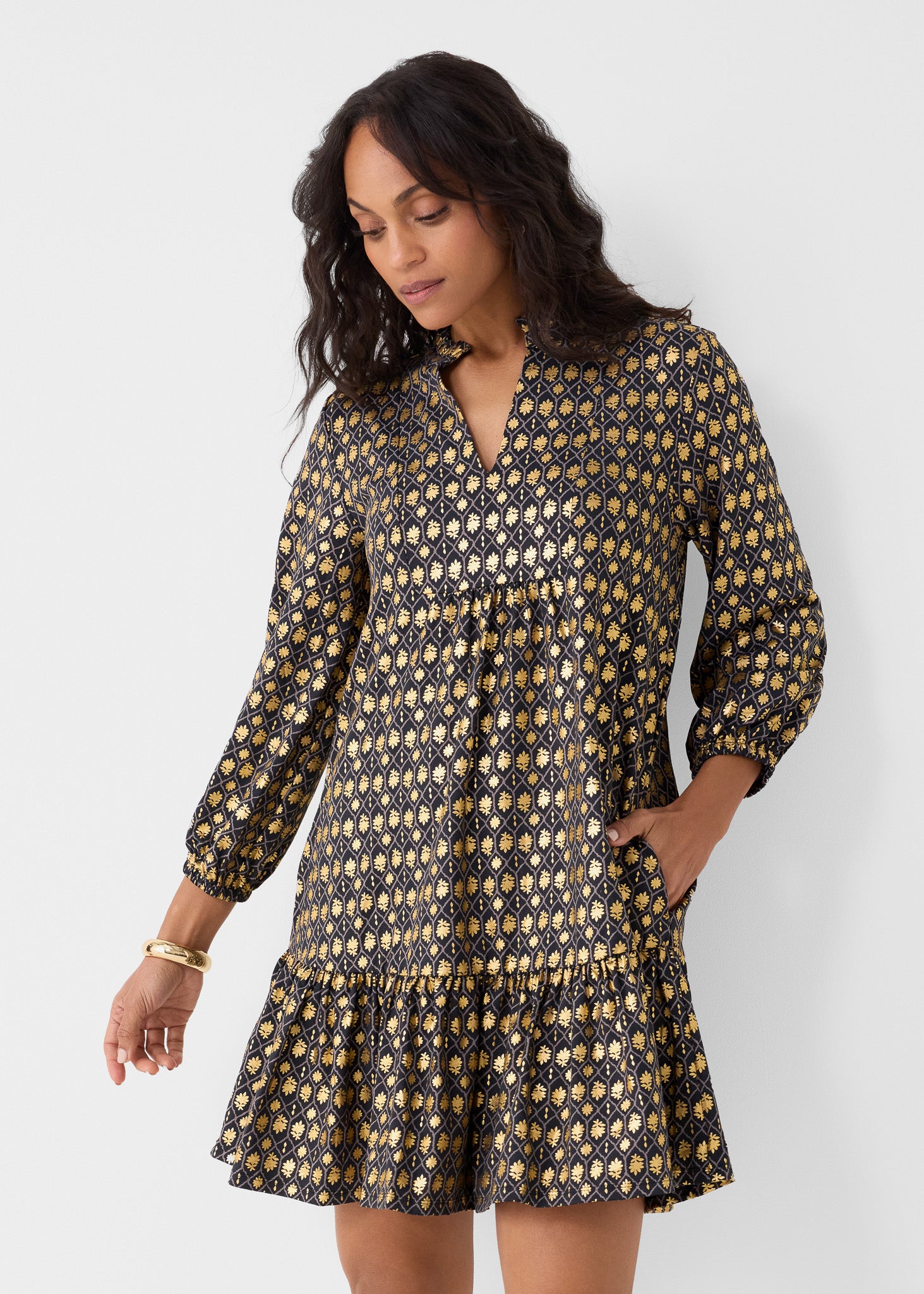 Woman wearing a patterned dress against a white background