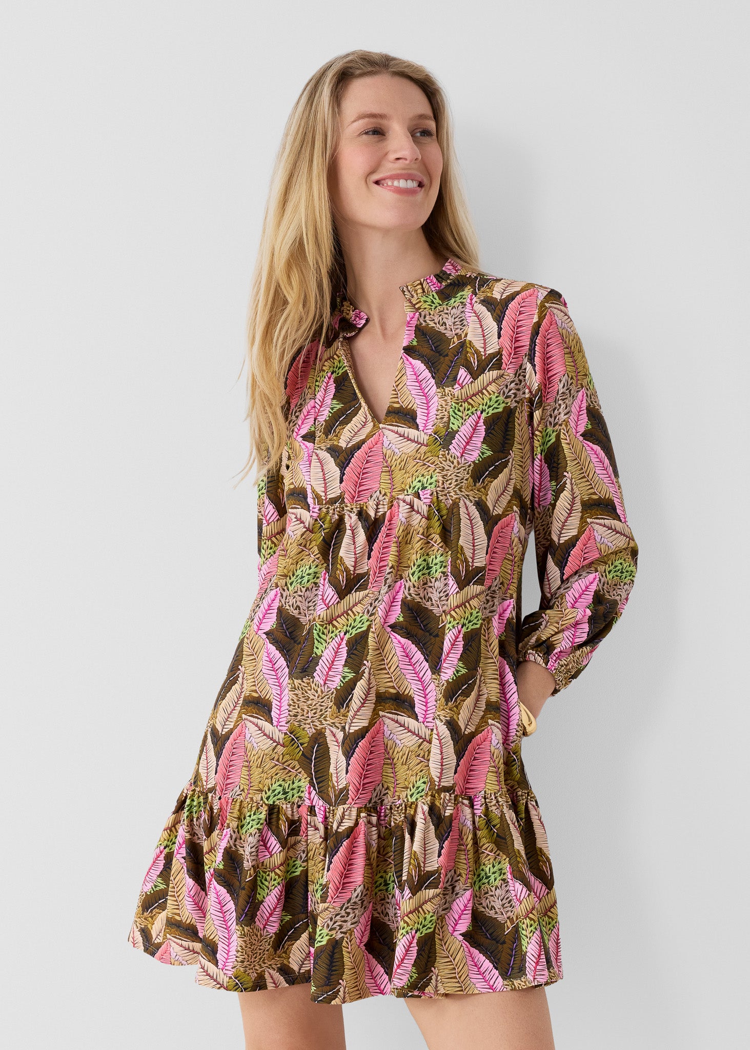 Woman wearing our Myers Relaxed Dress on a plain background with her hands in her pockets.