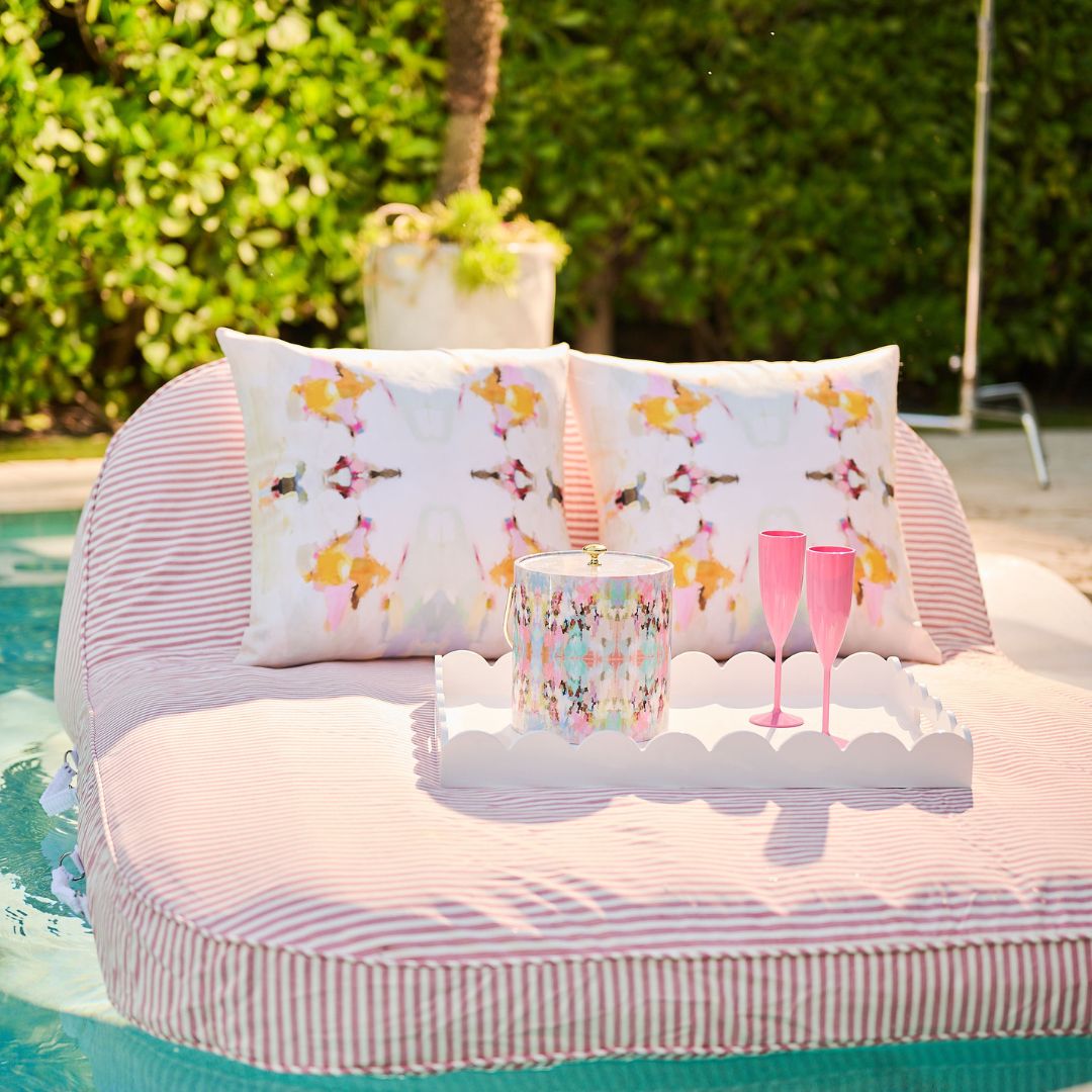 Pillow with butterfly pattern on a pool float with drinks and a candle