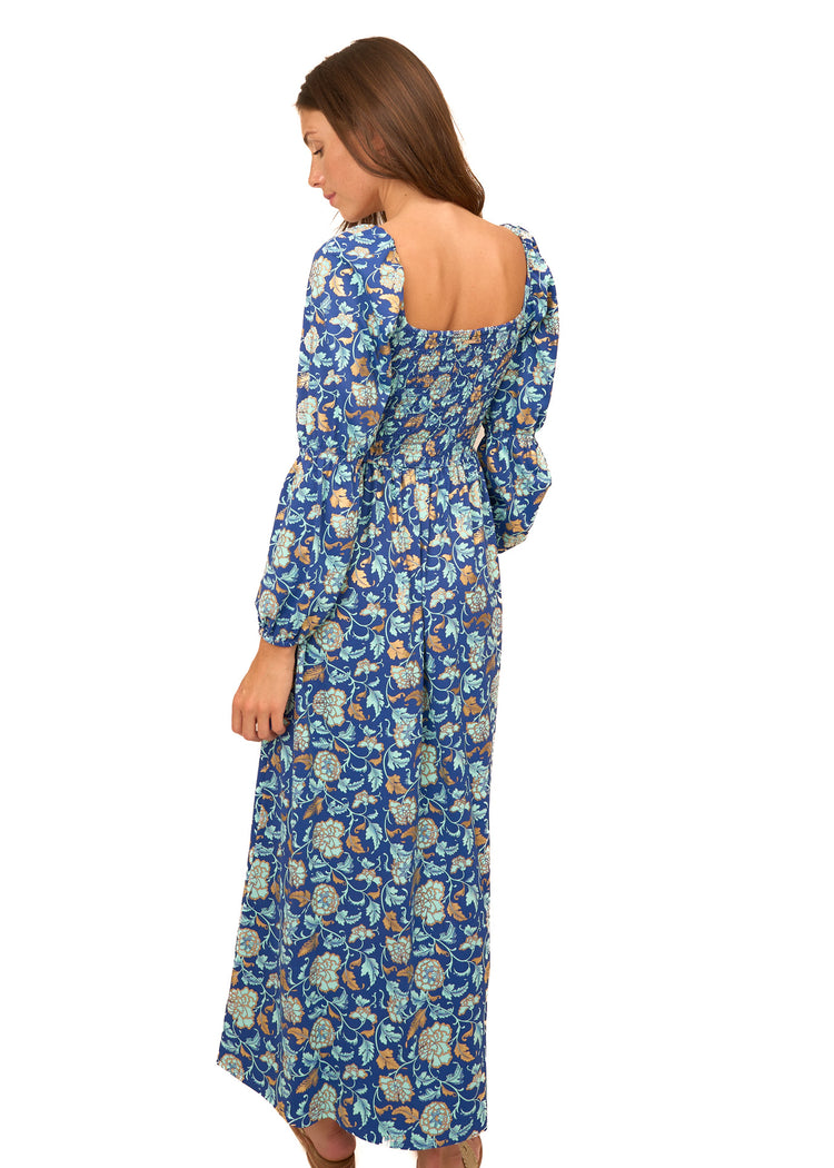 The back of a brunette woman wearing Cabana Life's sun protective Navy Floral Metallic Puff Sleeve Maxi Dress on a white background.