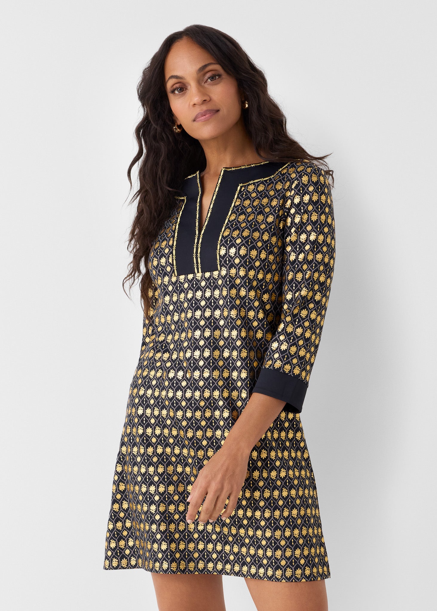 Woman wearing a patterned dress with a plain background