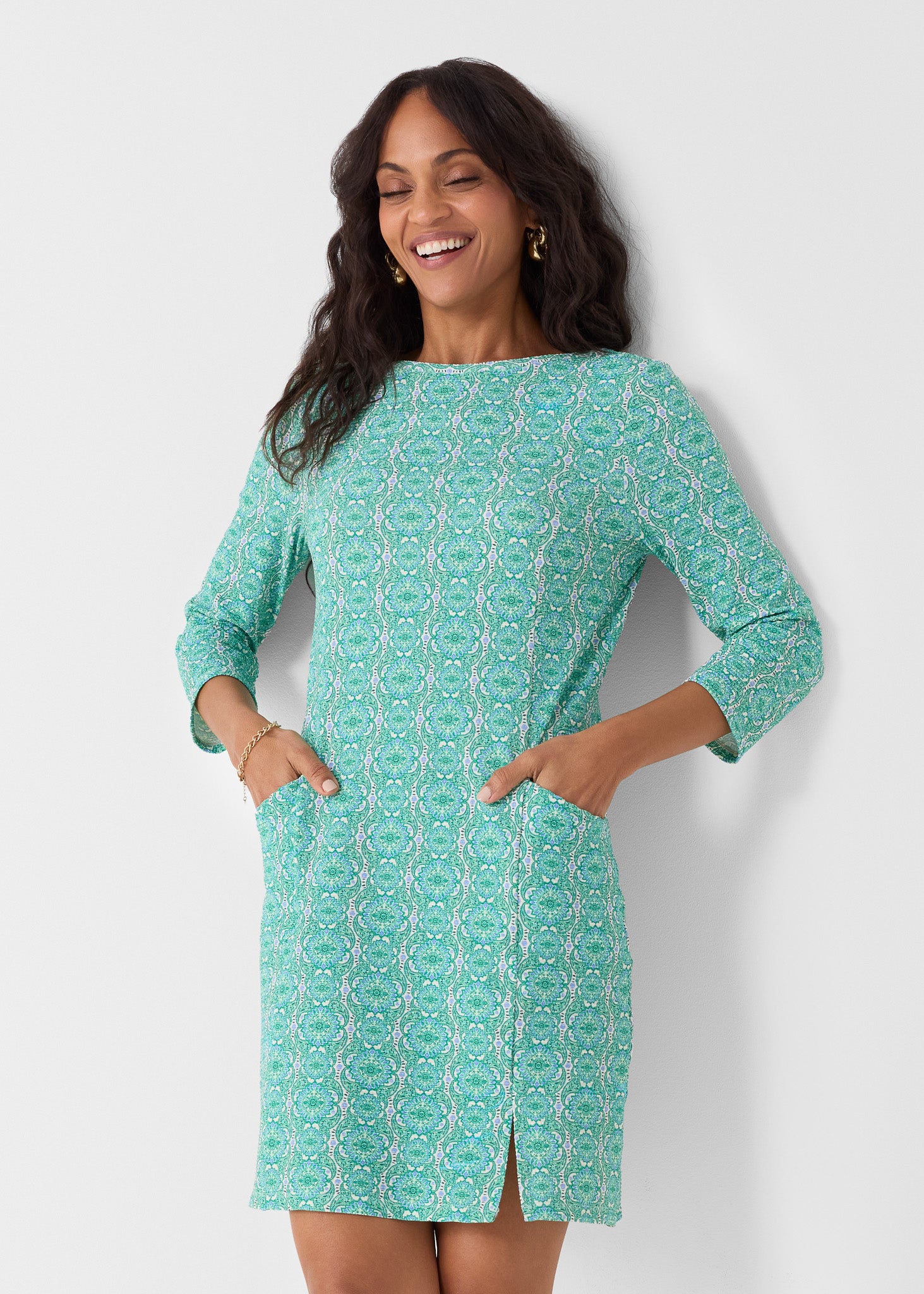 Woman wearing a green patterned dress against a white background