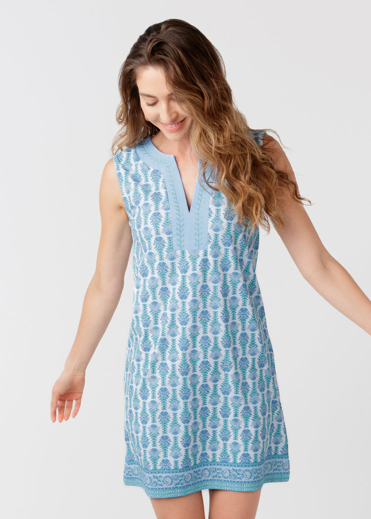 Woman wearing a blue patterned dress on a white background