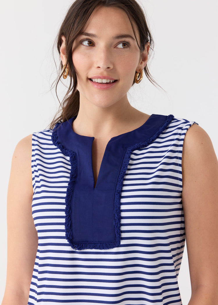 A dark haired woman wearing the Cabana Life sun protective Navy Stripe Sleeveless Fringe Tunic Dress with gold hoop earrings.
