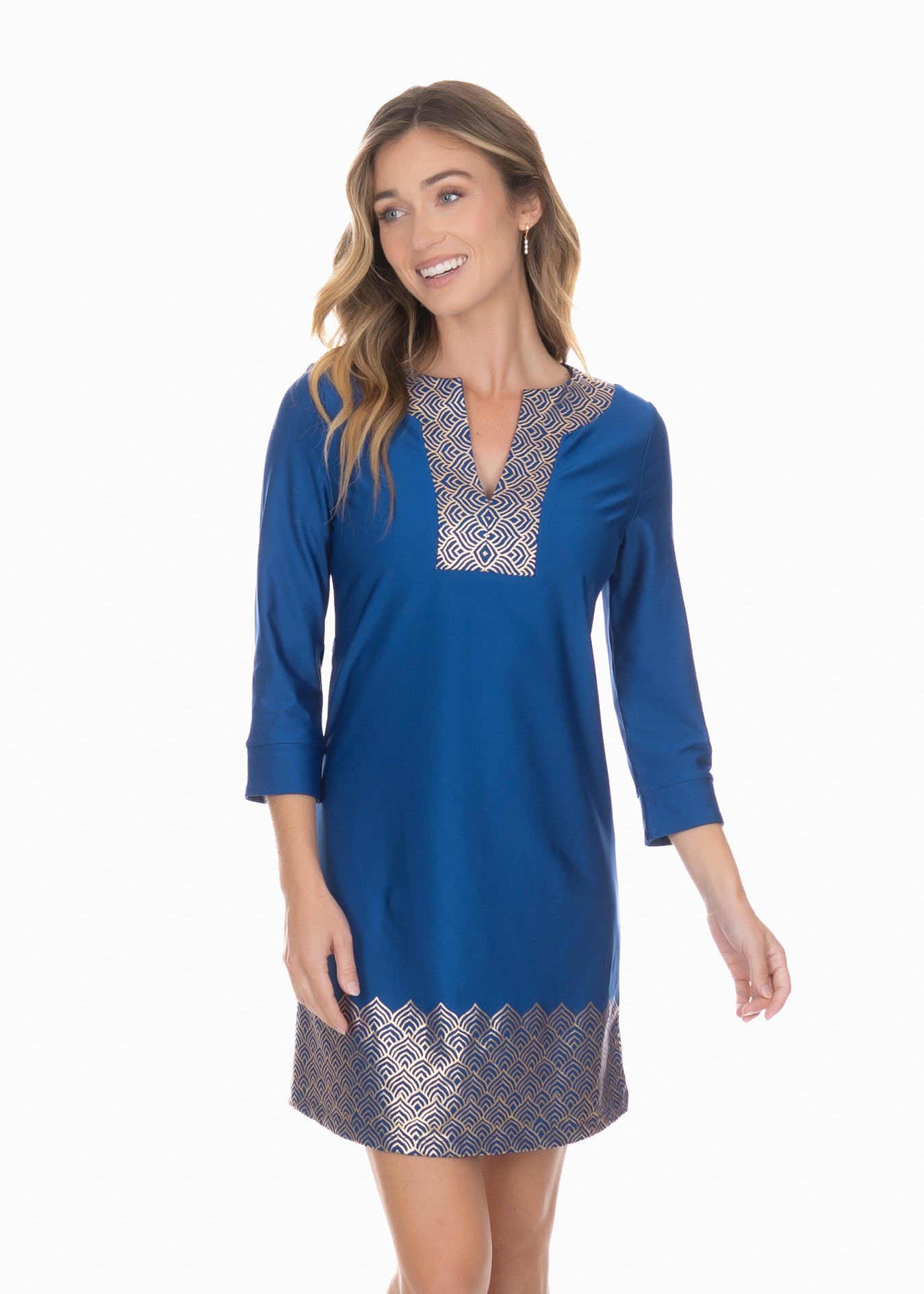 Smiling blonde woman wearing the Navy Metallic Tunic Dress with hands at side.