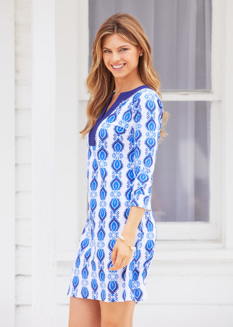 Side of woman wearing San Sebastian Embroidered Tunic Dress against white building