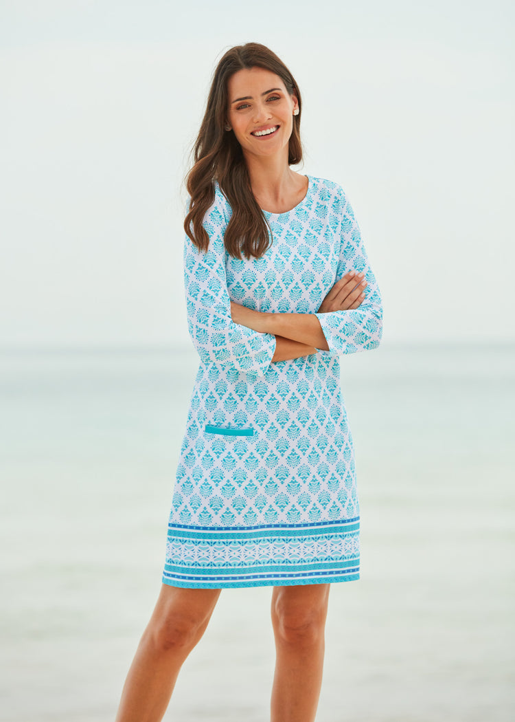 Woman wearing a blue patterned dress against a white background