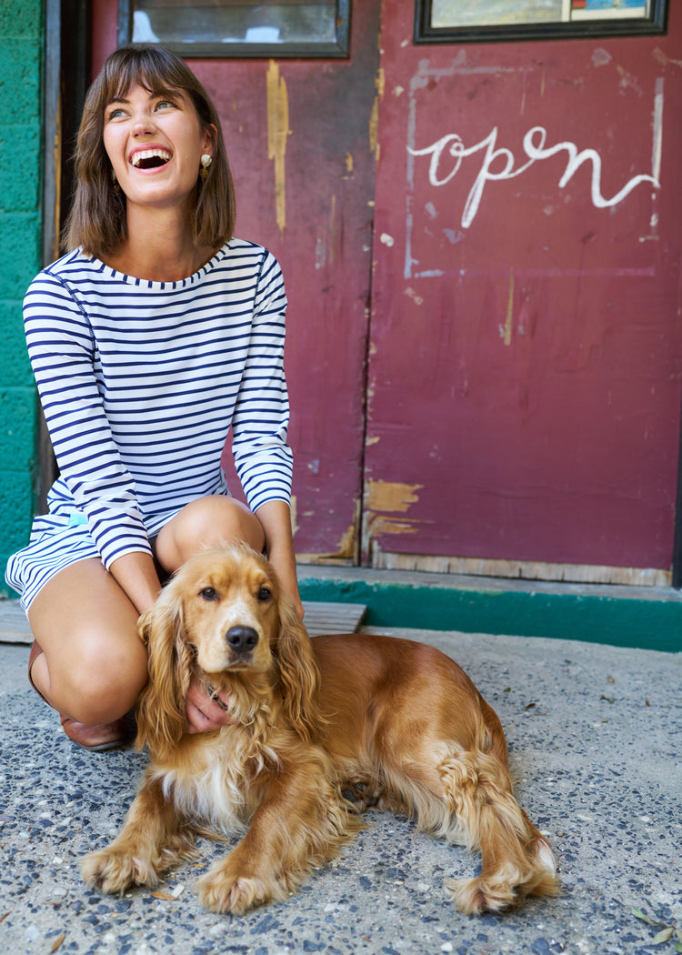 Woman wearing Navy Stripe Cabana Shift Dress sitting down with brown dog