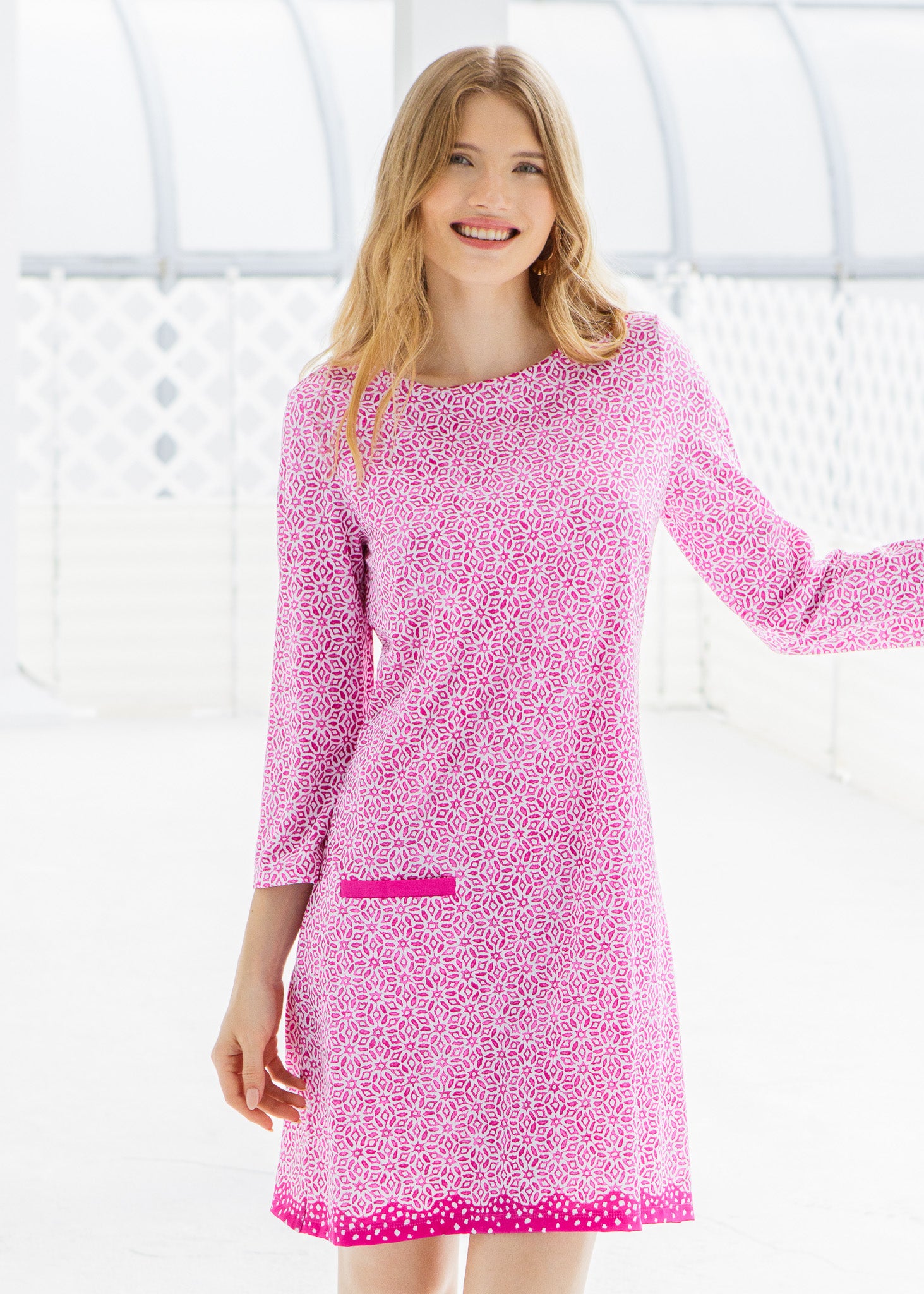 Woman wearing a pink patterned dress against a white background