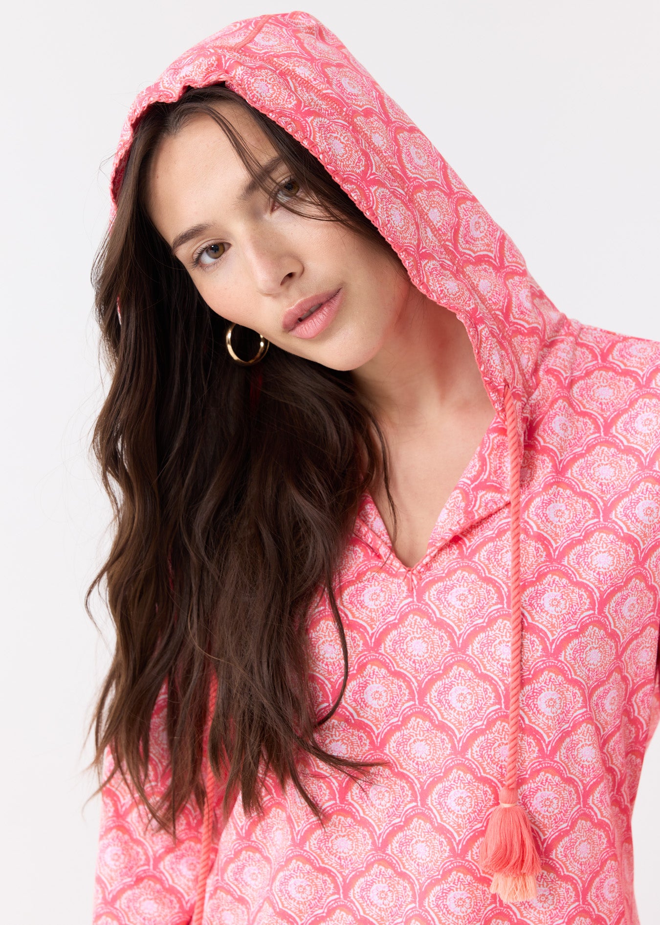 A dark haired woman wearing the Cabana Life sun protective Amelia Island Hooded Cover Up with the hood up.