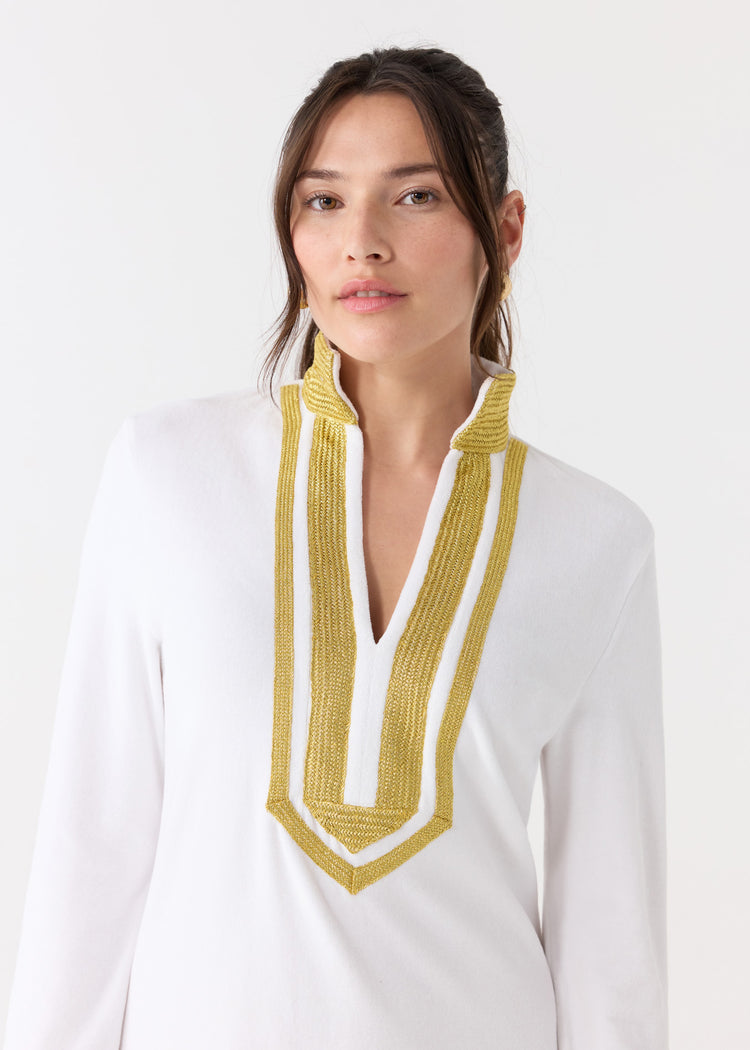 A woman with her dark hair up wearing the sun protective Cabana Life White/Gold Terry Tunic.