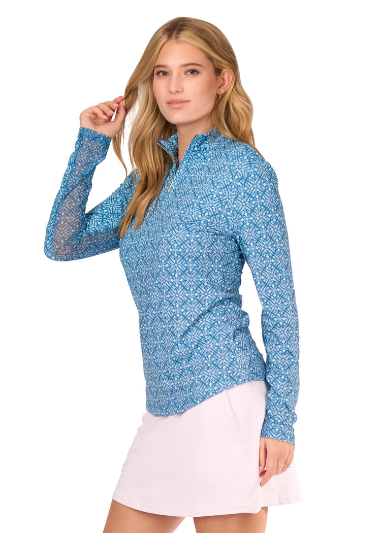 The side of a blonde woman wearing the sun protective & turquoise patterned Camden 1/4 Zip Sport Top and White 14" Skort from Cabana Life on a white background.
