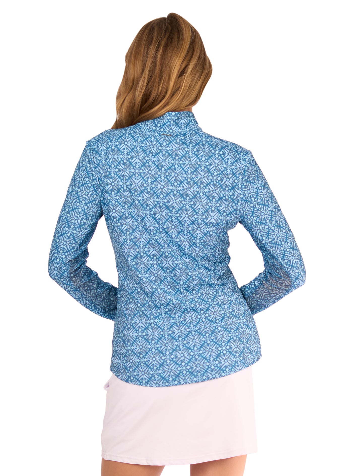 The back of a blonde woman wearing the sun protective & turquoise patterned Camden 1/4 Zip Sport Top and White 14" Skort from Cabana Life on a white background.