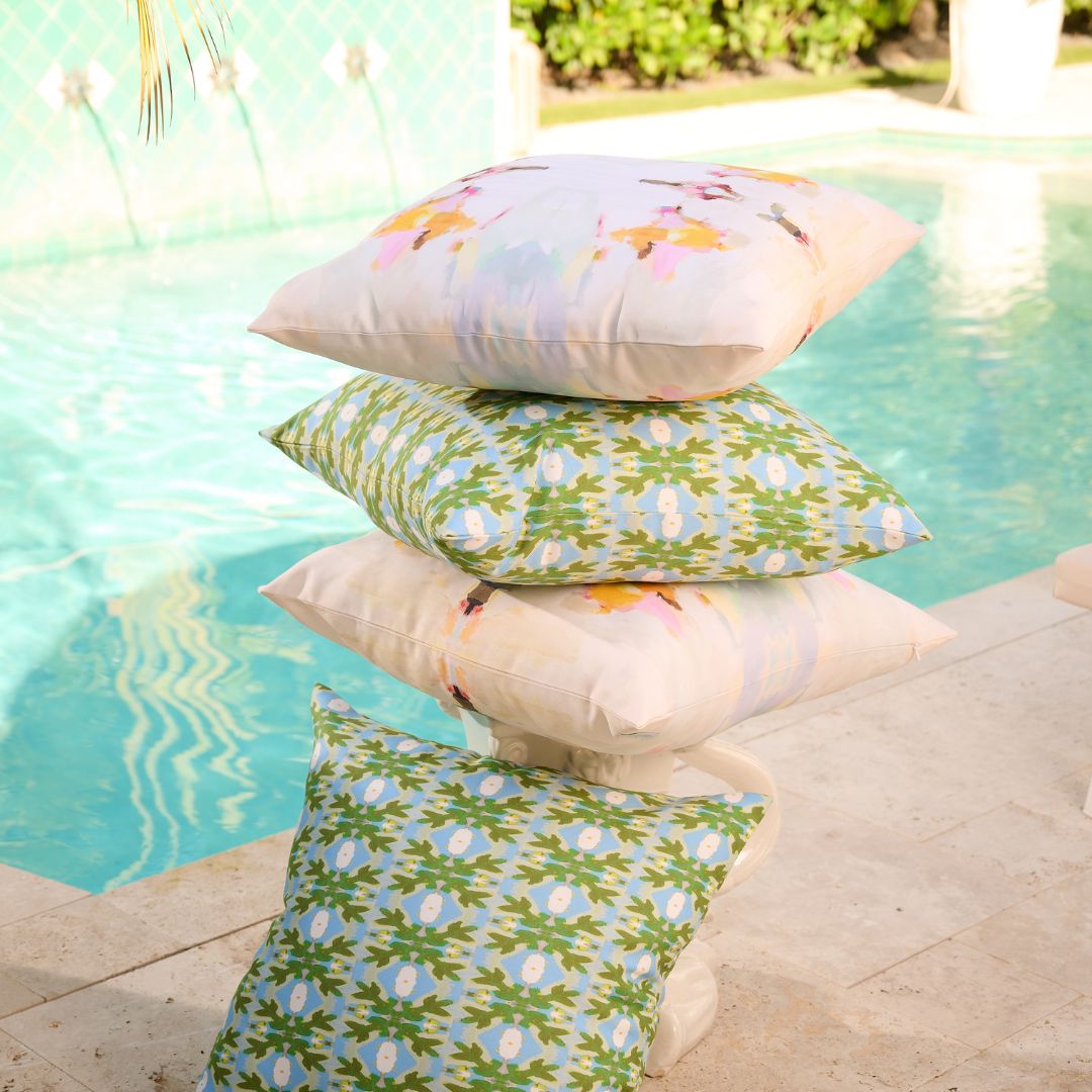 Stack of patterned pillows by a poolside
