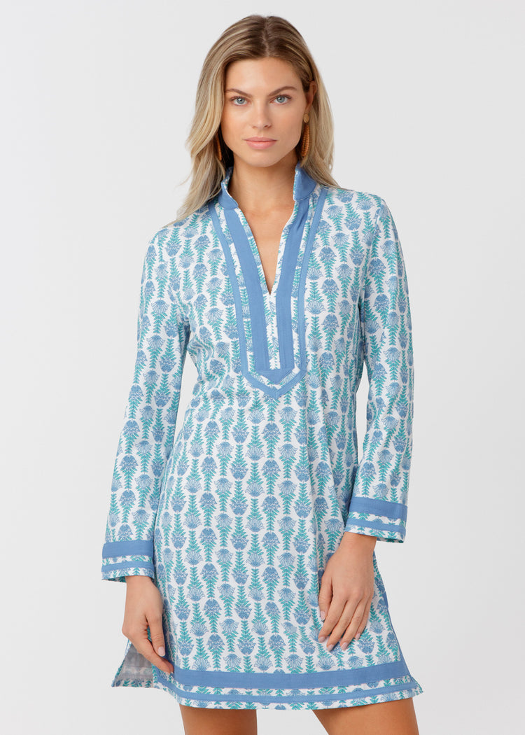 Woman wearing a blue and white patterned dress on a light gray background