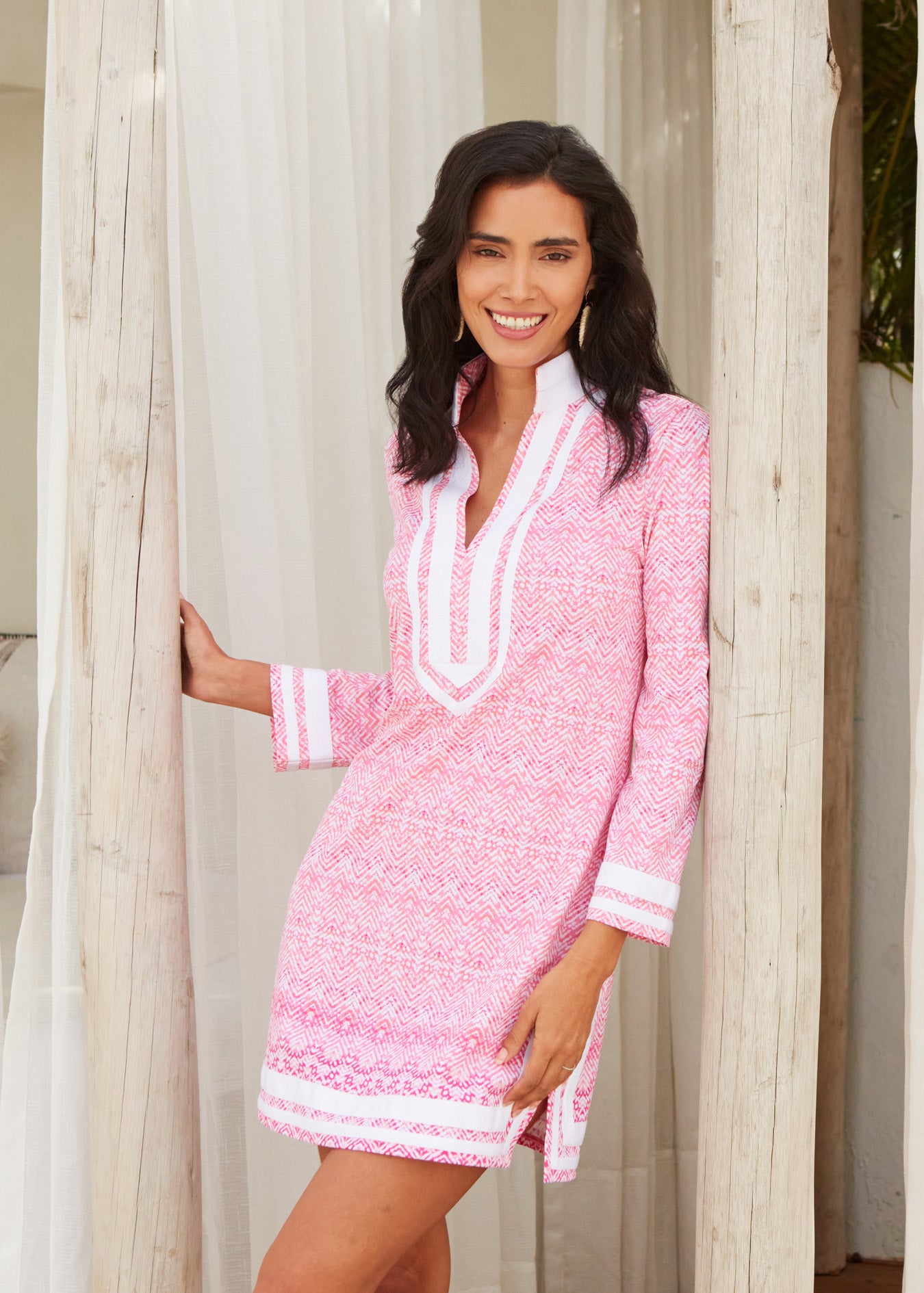 Dark haired woman leaning against wood pole wearing Algarve Tunic Dress.