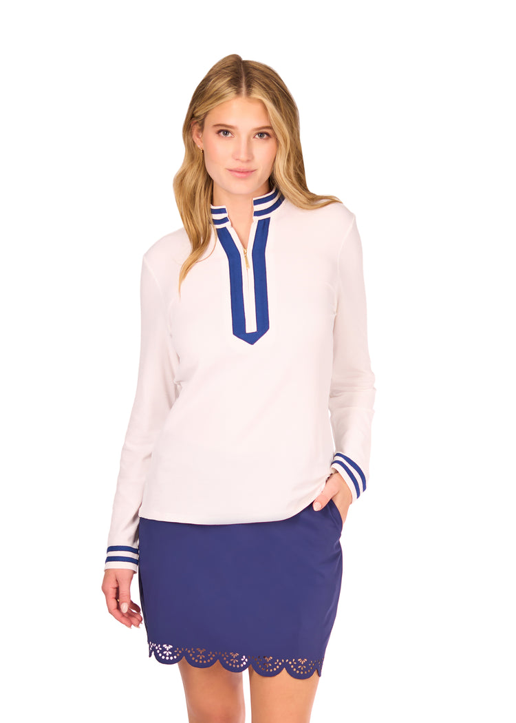 Woman in White Collared 1/4 Zip and Navy Scallop Skort