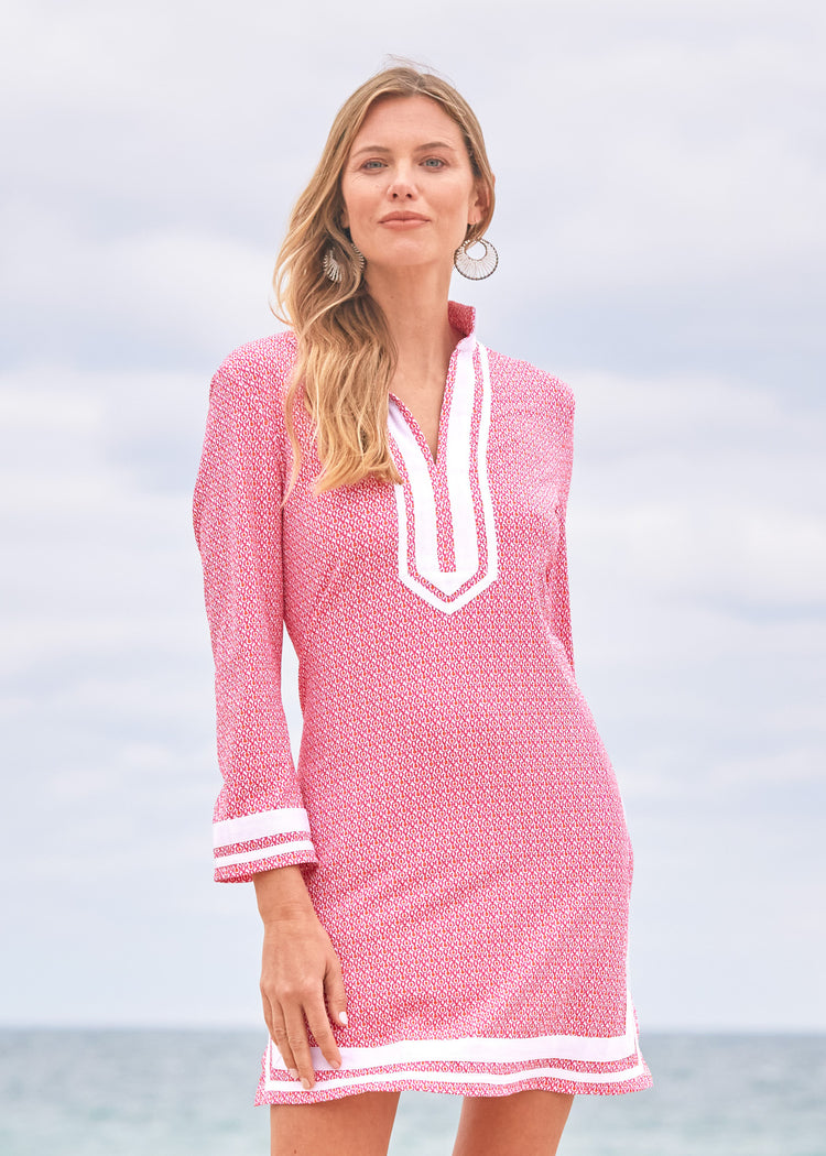 A blonde woman walking on the beach wearing the Cabana Life sun protective Amelia Island Tunic Dress.