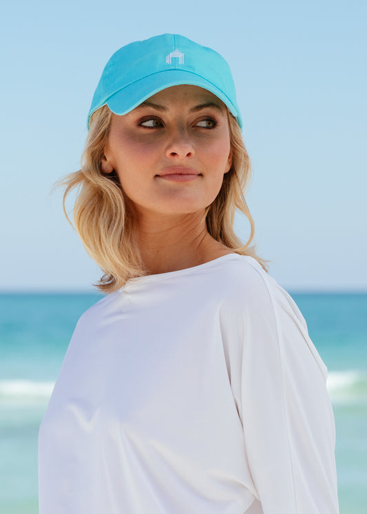 Blonde woman looking to side wearing Aqua Cabana Life Baseball Hat with white rashguard