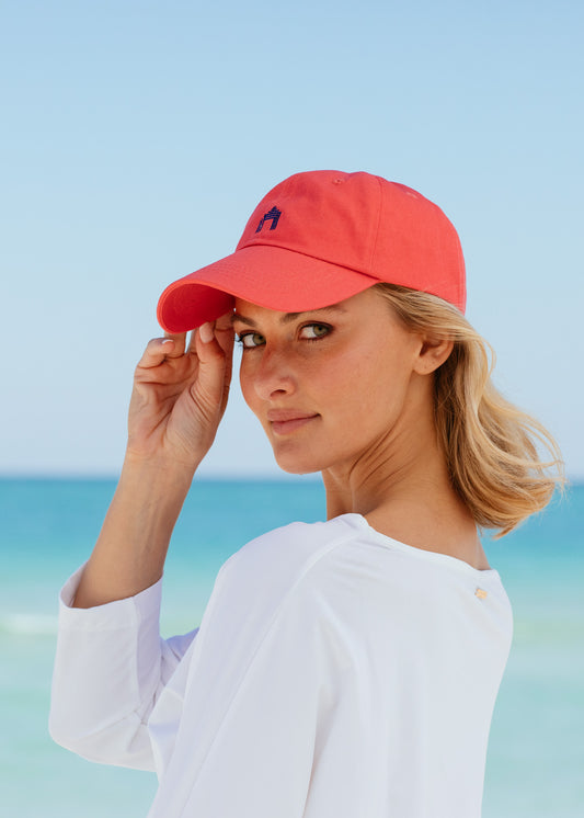 Blonde woman looking back wearing Nantucket Red Cabana Life Baseball Hat with white rashguard.