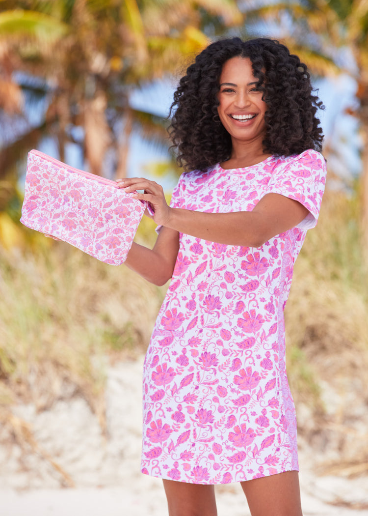 Woman wearing Provence Short Sleeve Dress holding up Provence Small Accessory Bag in front of palm trees