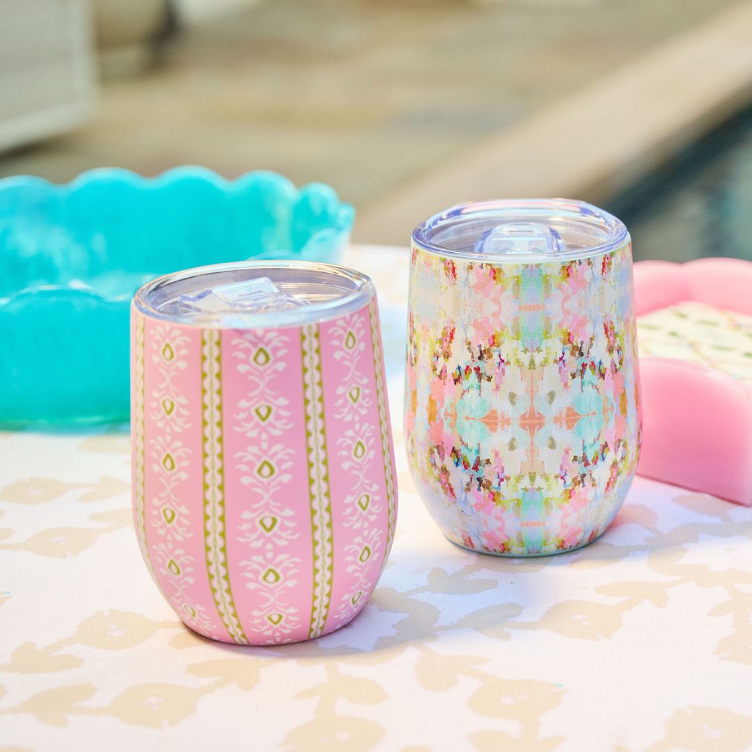 Two patterned tumblers on a surface with a blurred background