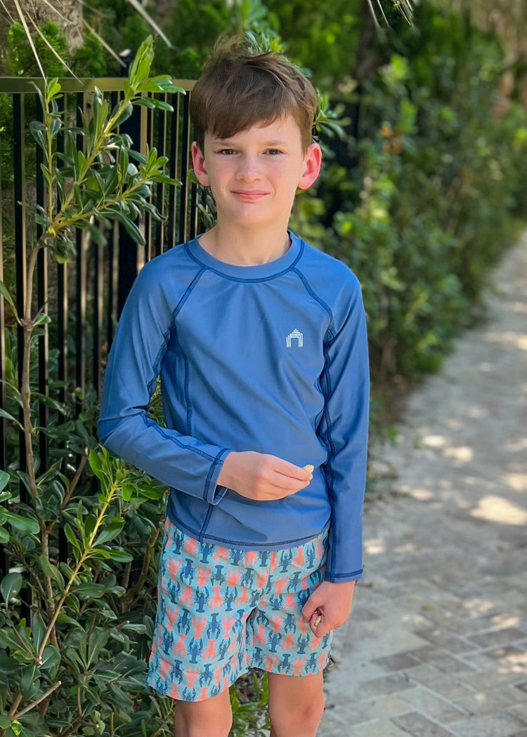 Boy wearing Light Blue Long Sleeve Rashguard and Lobster Swim Trunks