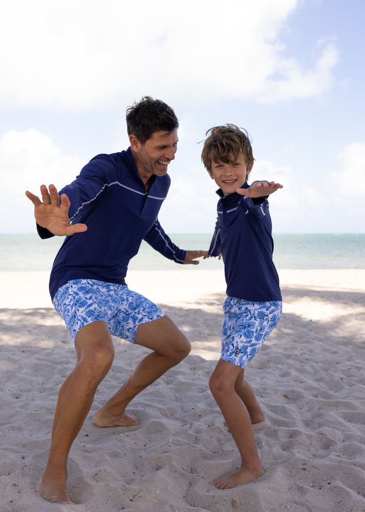 Father and son on beach wearing Men's Charleston Paisley Swim Trunks with Men's Navy Sport Zip Top and Boys Navy Sport Zip Top with Boys Charleston Paisley Swim Trunks