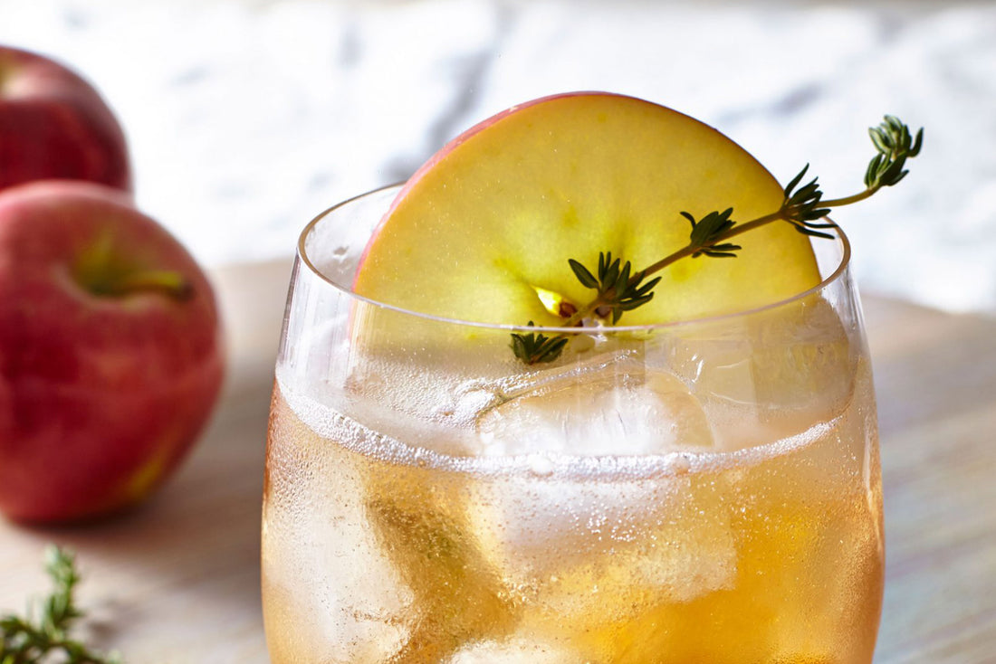 Bourbon Apple Cider Thyme Punch in glass with apple slice and thyme garnish