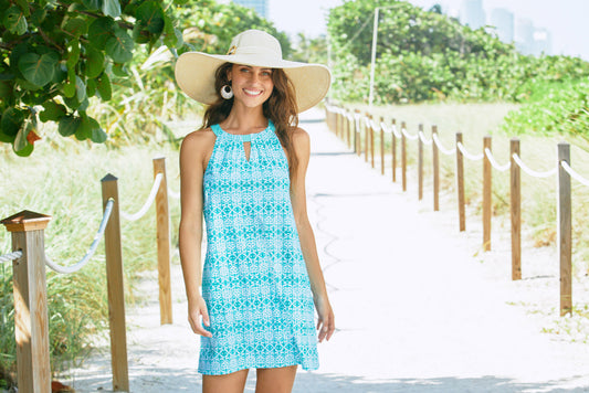 Woman on beach wearing Cabana Life Sunshine Shores Sleeveless Shift Dress with hat