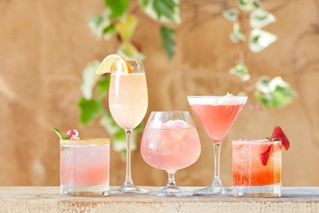 Pink and red cocktails in various glasses