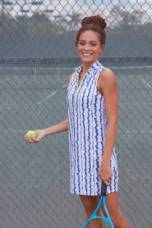 Woman wearing San Sebastian 1/4 Zip Sleeveless Sport Dress holding tennis ball and racquet