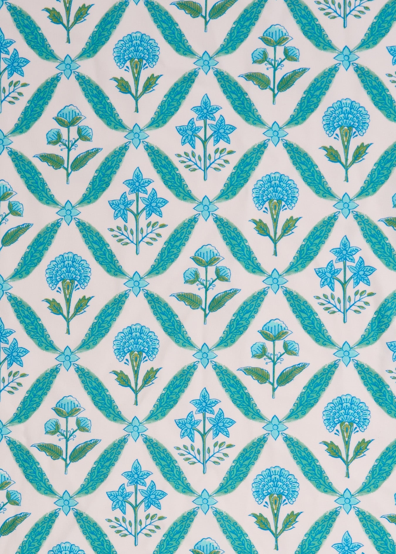 A close up of the sun protective green and blue floral tile pattern on the woven Cabana Life Rosemary Beach Smocked Maxi Dress.
