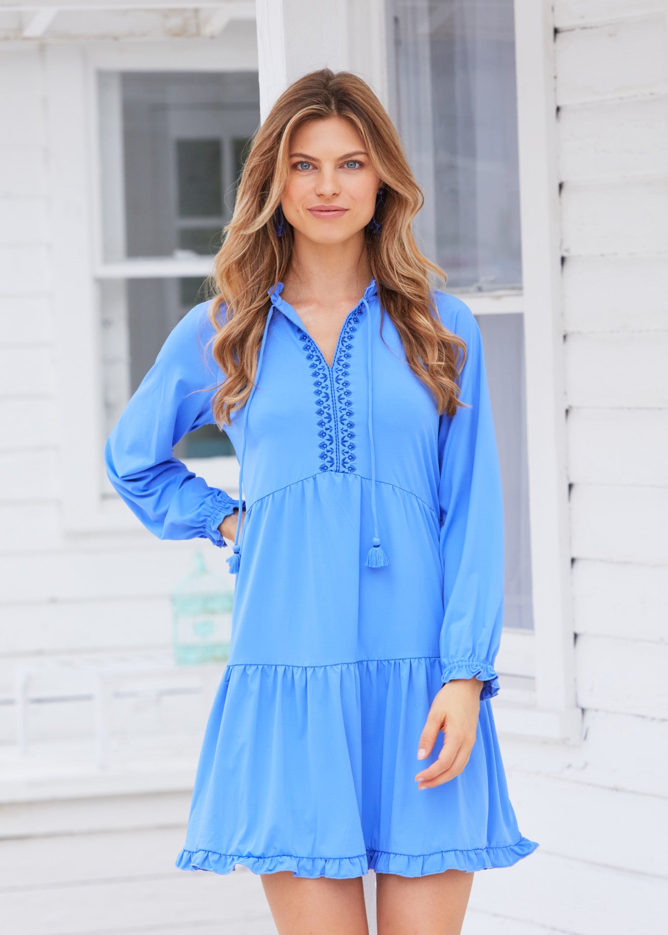 Blonde woman with wavy hair wearing Periwinkle Blue Embroidered Tiered Dressss in front of white house.