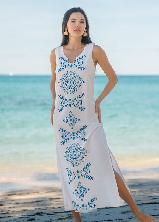Woman wearing a white maxi dress on the beach.