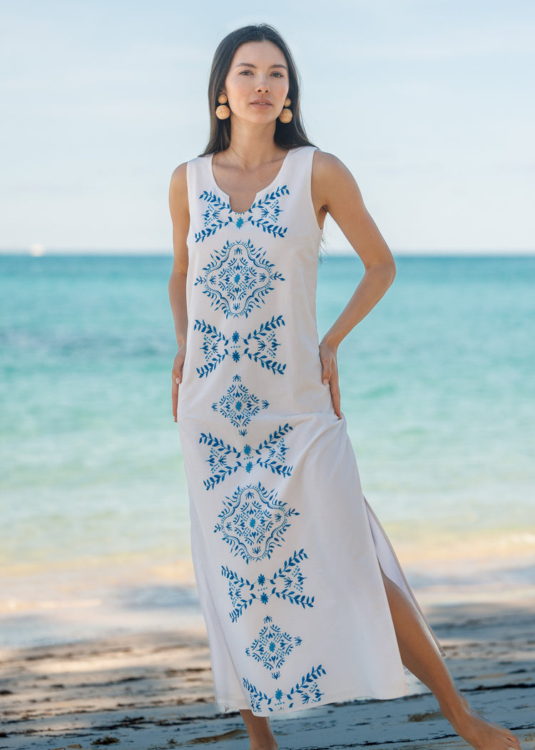 Woman wearing a white maxi dress on the beach.