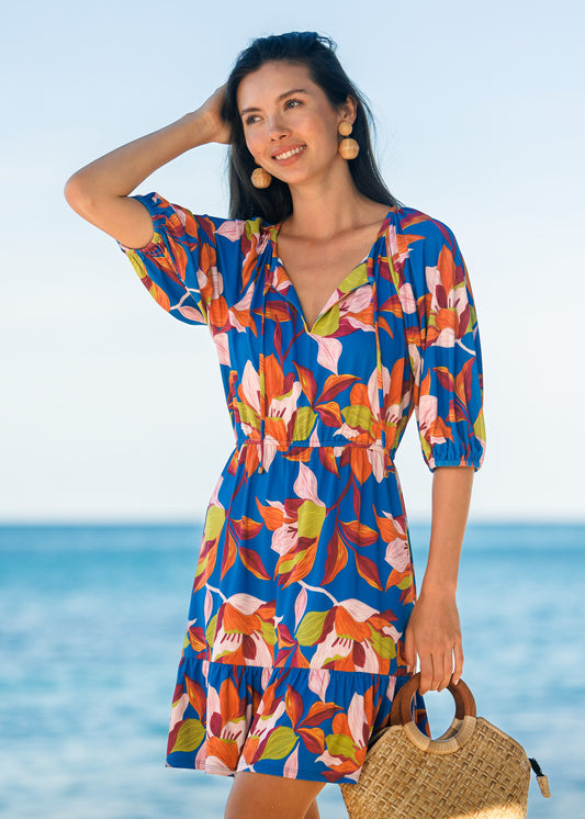 Woman in a colorful dress standing by the ocean