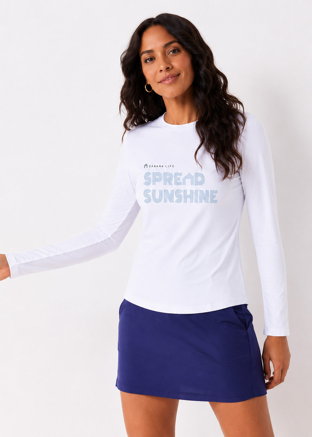 Woman wearing a white long-sleeve shirt with text and a blue skirt on a white background