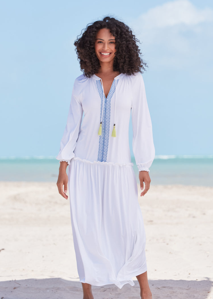 Woman wearing White Embroidered Tunic Maxi Dress with hands at side on beach.