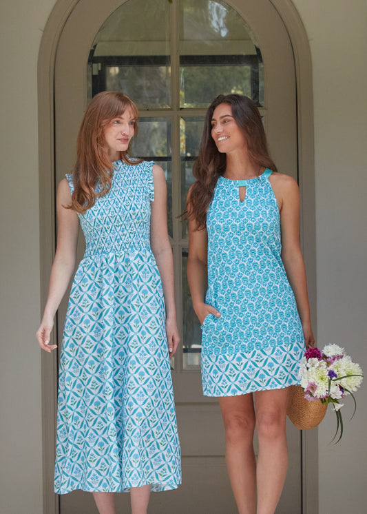 A redhead woman wearing the Cabana Life sun protective Rosemary Beach Smocked Maxi Dress walking with a brunette woman in the Rosemary Beach Sleeveless Shift Dress.