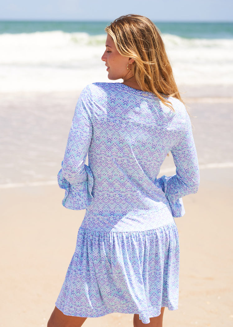 Woman wearing Naples embroidered drop waist dress.