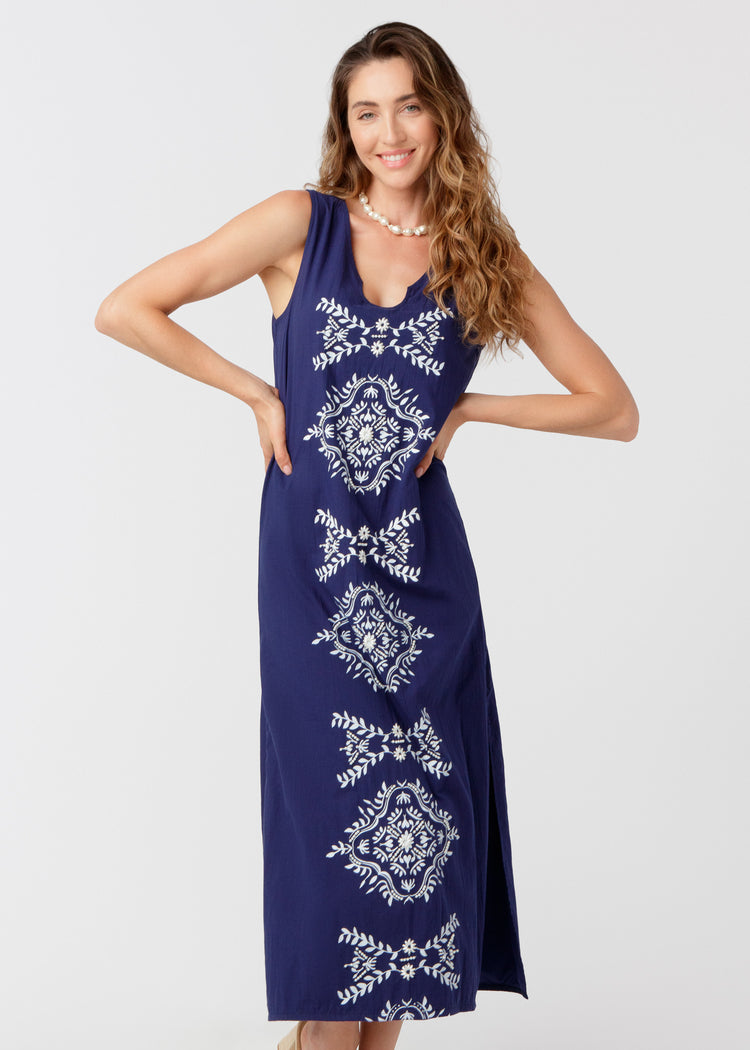 Woman wearing a navy maxi dress against a white background. 