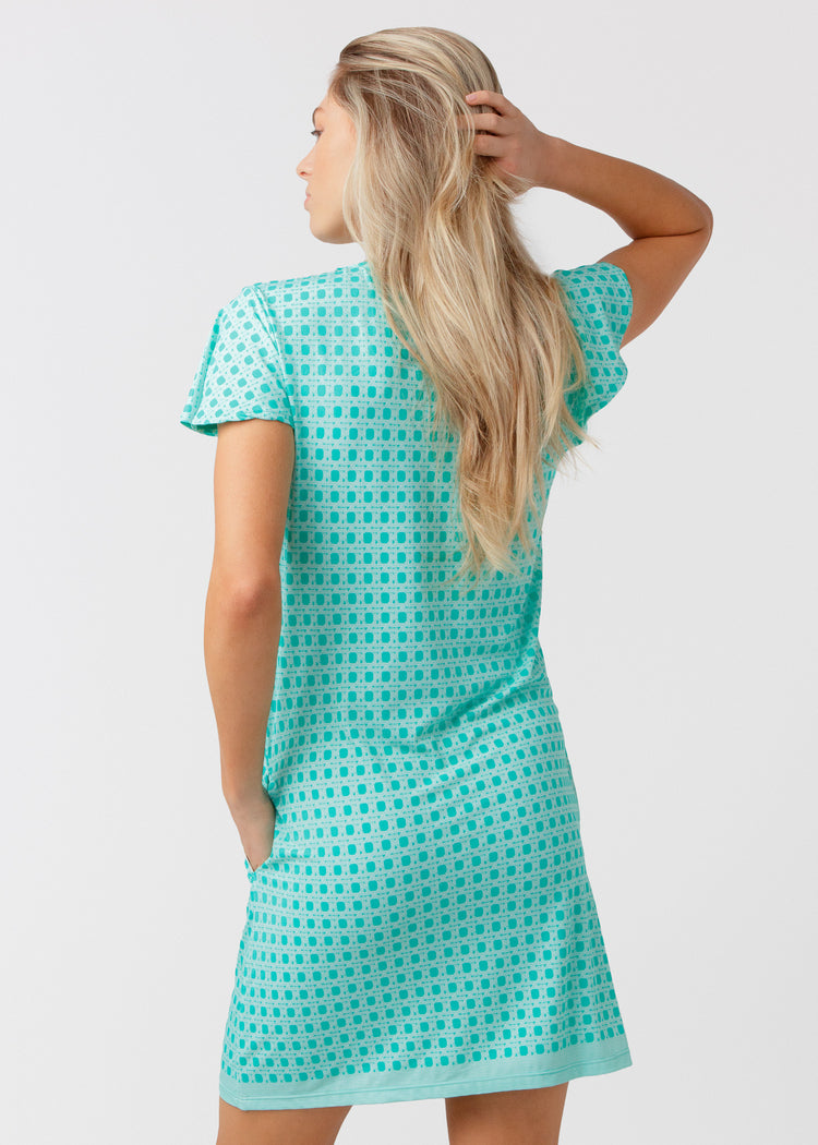 Woman wearing a green basketweave dress against a white background