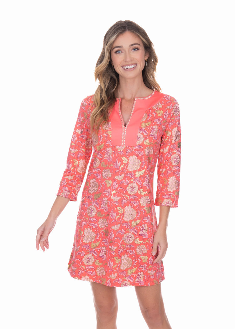 Front facing blonde model wearing the Coral Metallic Tunic Dress while smiling.