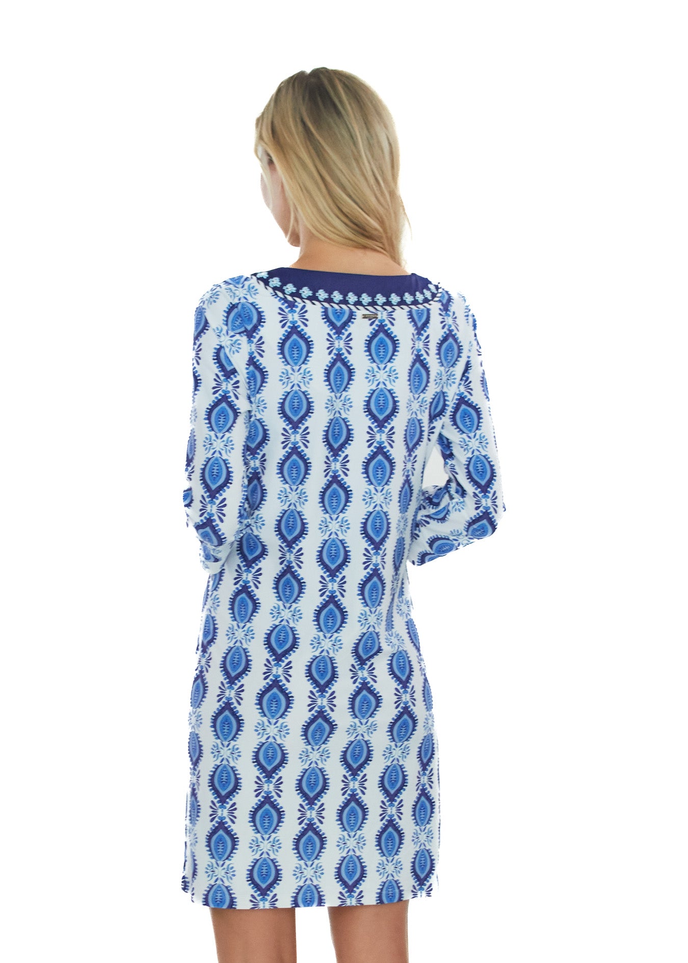 Back facing blonde woman wearing theSan Sebastian Embroidered Tunic Dress with arms in front. 