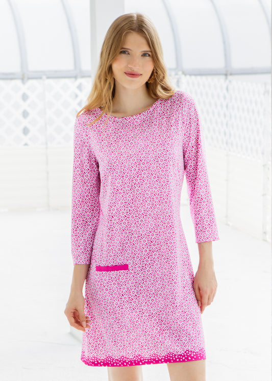 Woman wearing a pink patterned dress against a white background