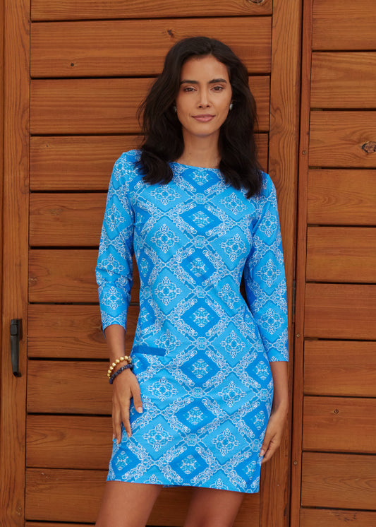 Woman in front of wood wall with hands at sides wearing Windermere Cabana Shift Dress.